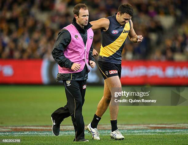 Shane Edwards of the Tigers comes from the ground with an injured leg during the round 15 AFL match between the Richmond Tigers and the Carlton Blues...