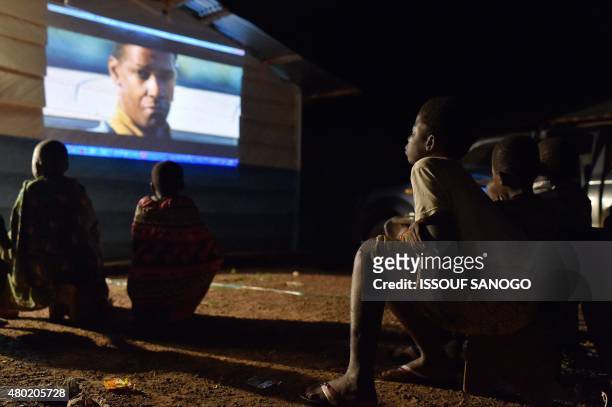 Children living in a cocoa farmers camp watch a movie in their camp near Abengourou, eastern Ivory Coast, on June 23, 2015. AFP PHOTO / ISSOUF SANOGO
