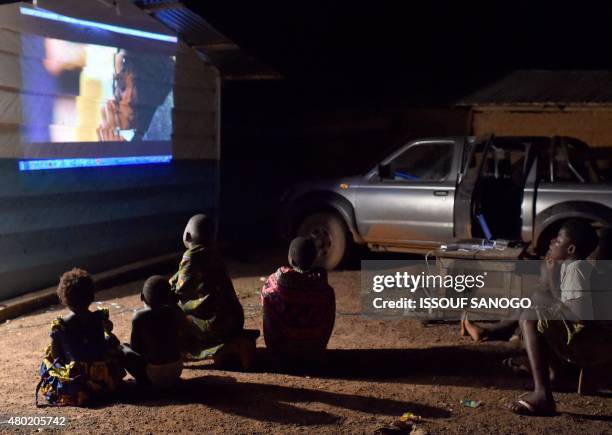 Children living in a cocoa farmers camp watch a movie in their camp near Abengourou, eastern Ivory Coast, on June 23, 2015. AFP PHOTO / ISSOUF SANOGO