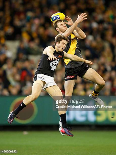 Kamdyn McIntosh of the Tigers and Jason Tutt of the Blues compete for the ball during the 2015 AFL round 15 match between the Richmond Tigers and the...