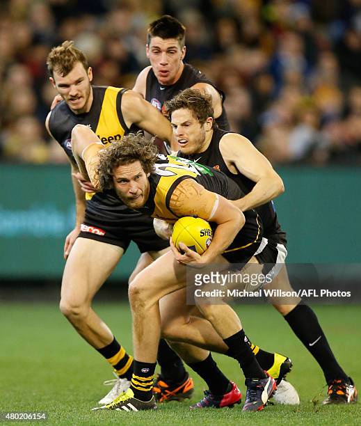 Ty Vickery of the Tigers is tackled by Jason Tutt of the Blues during the 2015 AFL round 15 match between the Richmond Tigers and the Carlton Blues...