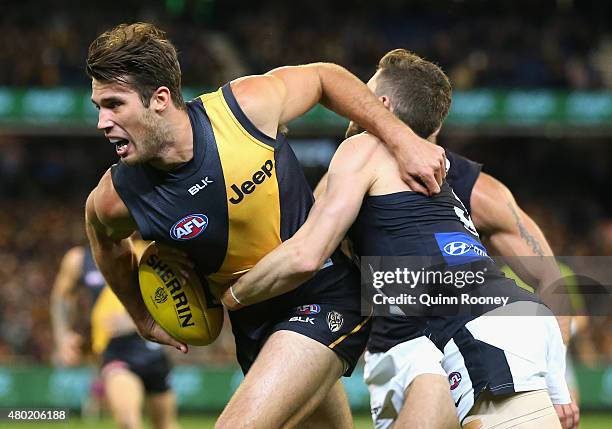 Alex Rance of the Tigers is tackled by Marc Murphy of the Blues during the round 15 AFL match between the Richmond Tigers and the Carlton Blues at...