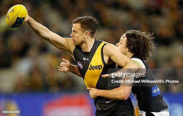 Brett Deledio of the Tigers is tackled by Dylan Buckley of the Blues during the 2015 AFL round 15 match between the Richmond Tigers and the Carlton...