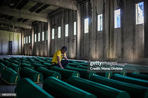 Man mourns over a coffin among 136 coffins of victims of the 1995 Srebrenica massacre in the hall at the Potocari cemetery and memorial near...