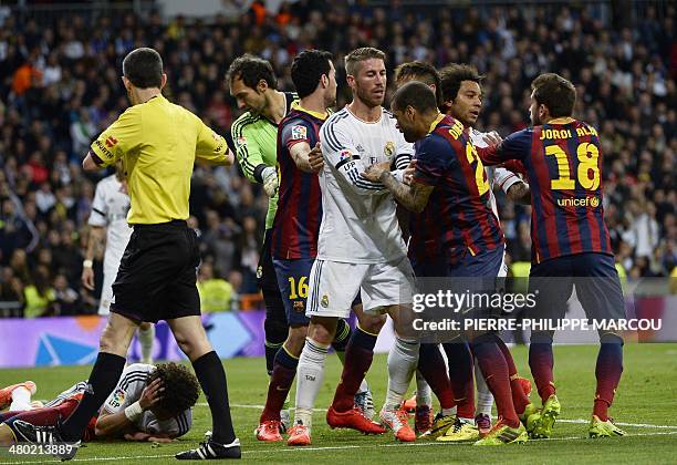 Barcelona's players vie with Real Madrid players as Real Madrid's Portuguese defender Pepe reacts during the Spanish league "Clasico" football match...