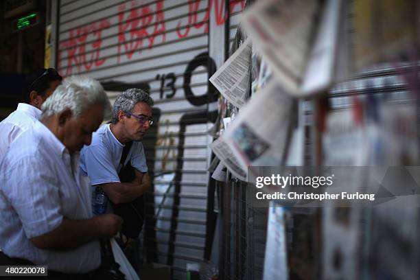 Men read the newspapers outside a newsagent on July 10, 2015 in Athens, Greece. Greek prime minister Alexis Tsipras is presenting the new debt...