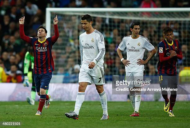 Lionel Messi of Barcelona celebrates scoring his team's third goal with Neymar of Barcelona as Cristiano Ronaldo and Angel Di Maria of Real Madrid...