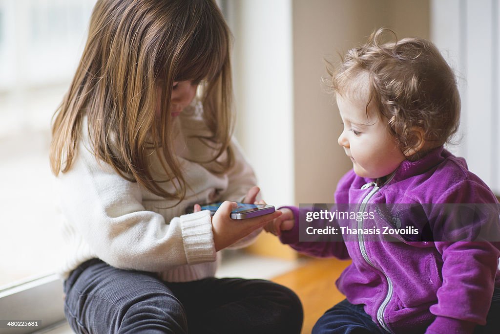 Small kids playing with a smartphone