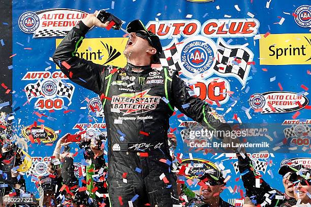 Kyle Busch, driver of the Interstate Batteries Toyota, celebrates in Victory Lane after winning the NASCAR Sprint Cup Series Auto Club 400 at Auto...