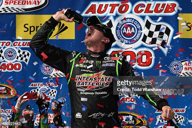 Kyle Busch, driver of the Interstate Batteries Toyota, celebrates in Victory Lane after winning the NASCAR Sprint Cup Series Auto Club 400 at Auto...