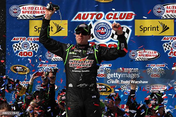 Kyle Busch, driver of the Interstate Batteries Toyota, celebrates in Victory Lane after winning the NASCAR Sprint Cup Series Auto Club 400 at Auto...