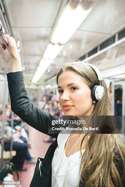 beautiful woman listening music on her smartphone on subway train - metro st petersburg stockfoto's en -beelden