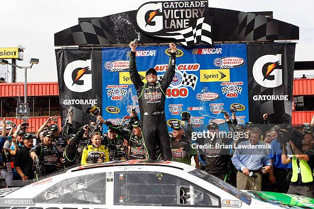 Kyle Busch, driver of the Interstate Batteries Toyota, celebrates in Victory Lane after winning the NASCAR Sprint Cup Series Auto Club 400 at Auto...