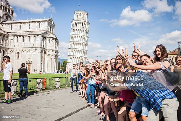 large group of tourist having fun in pisa - pisa italy stock pictures, royalty-free photos & images