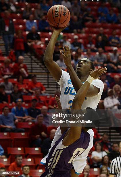 Jordan Adams of the UCLA Bruins shoots over Trey Pinkney of the Stephen F. Austin Lumberjacks in the first half during the third round of the 2014...