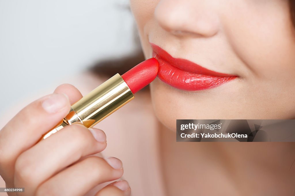 Cheerful young girl is doing her make-up