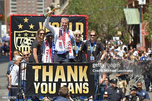 Soccer player Carli Lloyd, Chirlane McCray, Mayor Bill de Blasio, soccer player Megan Rapinoe, and U.S. Coach Jill Ellis aboard a float in the New...