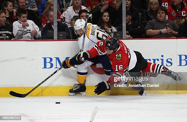 Marcus Kruger of the Chicago Blackhawks hits the ice as he battles for the puck with Victor Bartley of the Nashville Predators at the United Center...