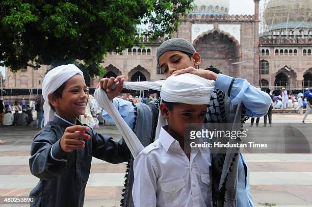 Muslim boy tying turban before offering Friday Namaz at Taj-ul-Masajid during the ongoing holy month of Ramadan on July 10, 2015 in Bhopal, India....