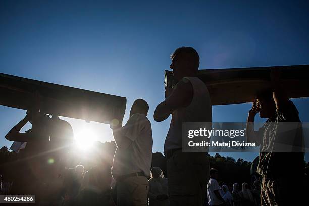 Volunteers carry some of the 136 coffins of victims of the 1995 Srebrenica massacre from the hall at the Potocari cemetery and memorial near...