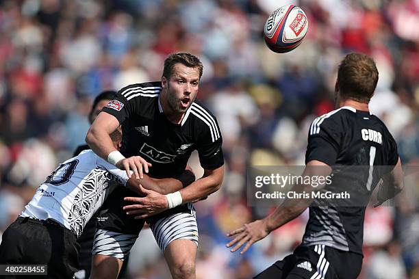 Tim Mikkelson of New Zealand gets a pass away under pressure from Osea Kolinisau of Fiji during the Tokyo Sevens, in the six round of the HSBC Sevens...