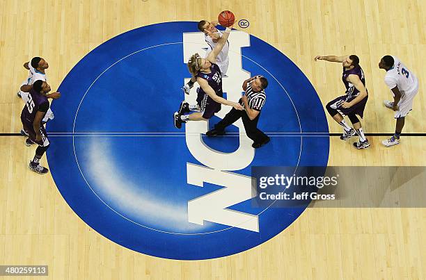 Jacob Parker of the Stephen F. Austin Lumberjacks tips-off against Travis Wear of the UCLA Bruins to start their game during the third round of the...