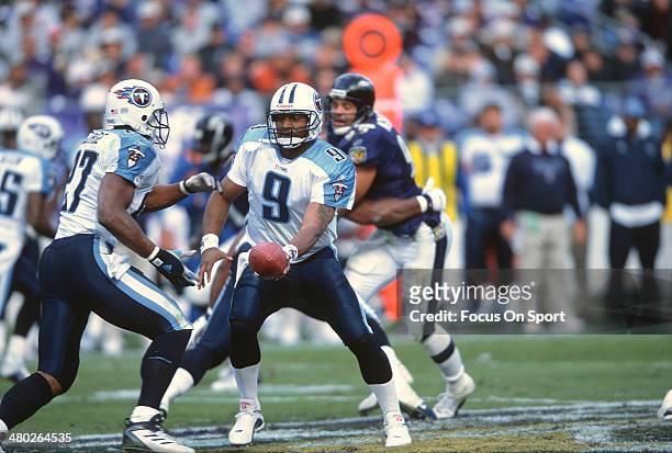Steve McNair of the Tennessee Titans turns to hand the ball off to Eddie George against the Baltimore Ravens during an NFL football game October 7,...