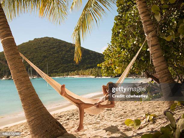 woman relaxing in a hammock at jost van dyke, bvi - caraïbische zee stockfoto's en -beelden