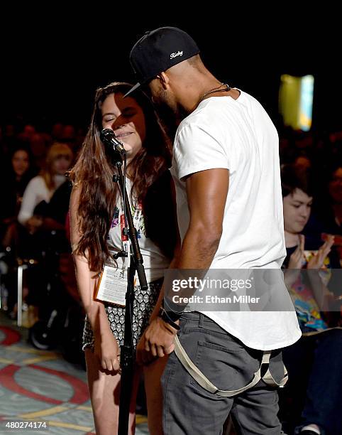 Actor Ricky Whittle embraces fan Kayla Vlcek as she asks a question at a special video presentation and panel for "The 100" during Comic-Con...