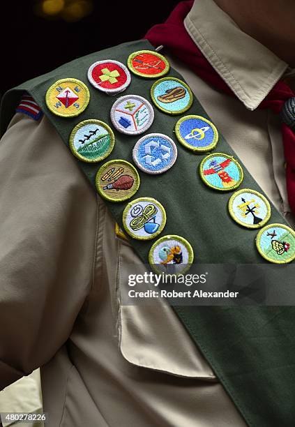 Boy Scout wears a sash displaying his earned merit badges at a ceremony in New York City. The merit badge sash is worn by a Boy Scout during formal...
