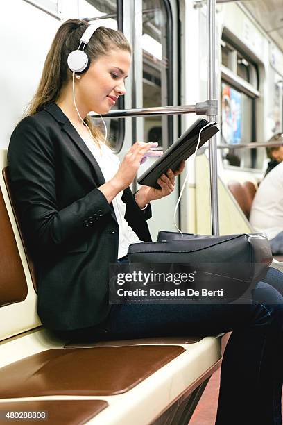 beautiful woman listening music on her tablet on subway train - metro st petersburg stockfoto's en -beelden