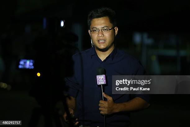 Malaysian television reporter performs a live cross after an RAAF P3 Orion returned to Pearce air base after sighting debris in a search mission on...