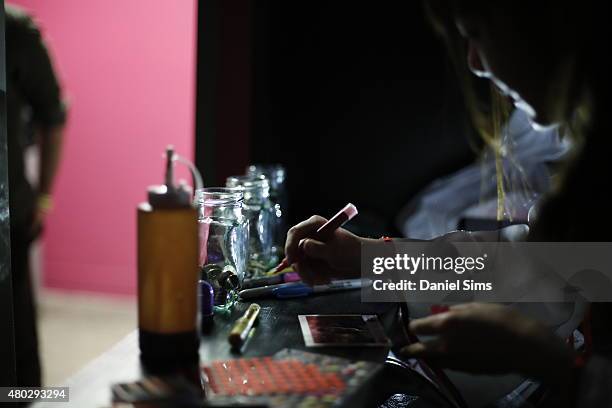 Japanese style maid customises an instant film photo with marker pens at Hyper Japan, the UK's biggest Japanese culture event on July 10, 2015 at The...