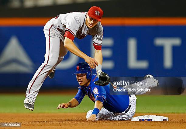 Wilmer Flores of the New York Mets slides into shortstop Nick Ahmed of the Arizona Diamondbacks who throws to first base to get Lucas Duda for a...