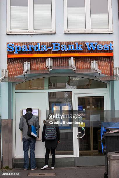 Customers use an automated teller machine outside a bank branch of Sparda-Bank West eG in Dusseldorf, Germany, on Saturday, March 22, 2014. Germany...