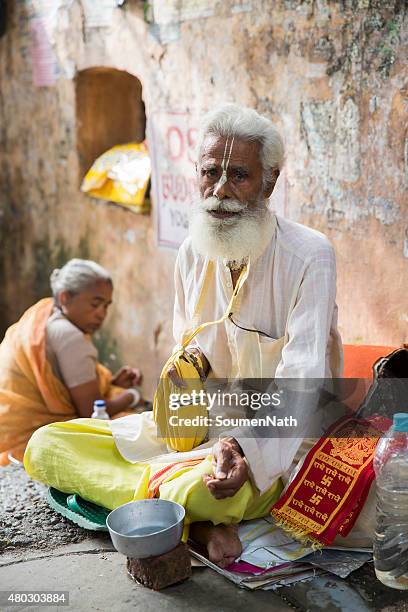 vaishnav hermit sits on the pavement asking for alms - rishikesh stock pictures, royalty-free photos & images