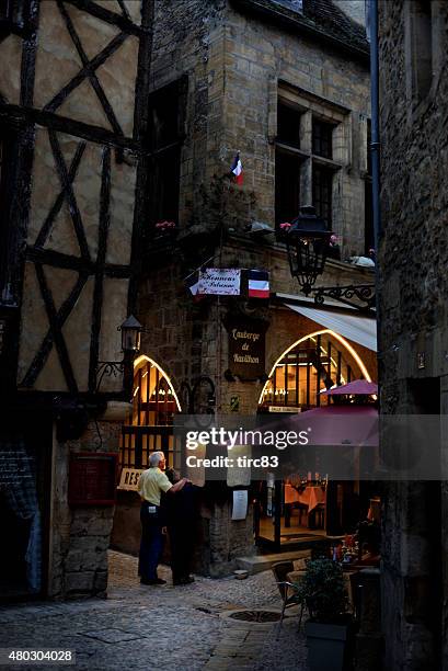 couple outside restaurant on cobblestone street - sarlat stock pictures, royalty-free photos & images