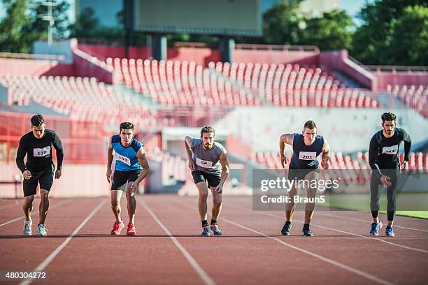 group of young runners on a starting line. - mens track stock pictures, royalty-free photos & images