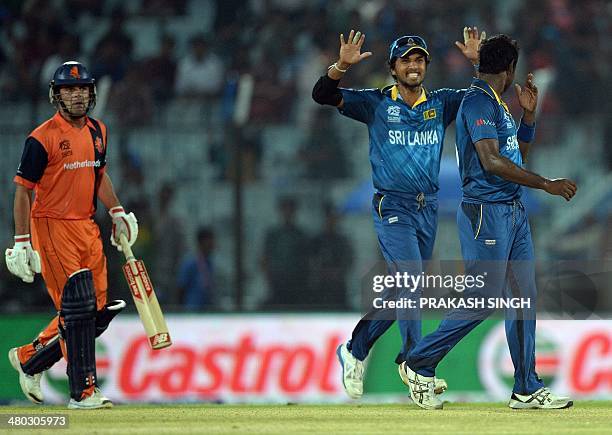 Sri Lanka cricket captain Dinesh Chandimal celebrates the wicket of Netherlands batsman captain Peter Borren with bowler Angelo Mathews during the...