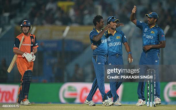 Sri Lanka cricket captain Dinesh Chandimal celebrates the wicket of Netherlands batsman captain Peter Borren with bowler Angelo Mathews during the...