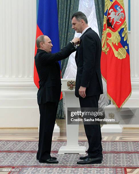 Russian President Vladimir Putin congradulates businessman Mikhail Prokhorov during a state award ceremony honoring participants of the Olympic and...