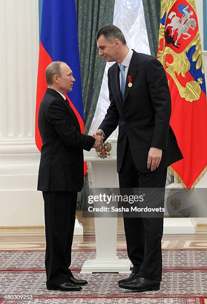 Russian President Vladimir Putin congradulates businessman Mikhail Prokhorov during a state award ceremony honoring participants of the Olympic and...