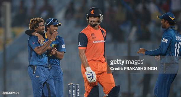 Sri Lanka cricket captain Dinesh Chandimal celebrates after Netherlands batsman Mudassar Bukhari was clean bowled by Lasith Malinga during the ICC...