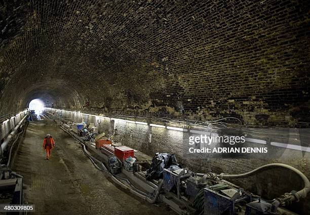Worker walks back into the Connaught tunnel, an old Victorian tunnel which is being brought back into use for Crossrail in London on March 24, 2014....