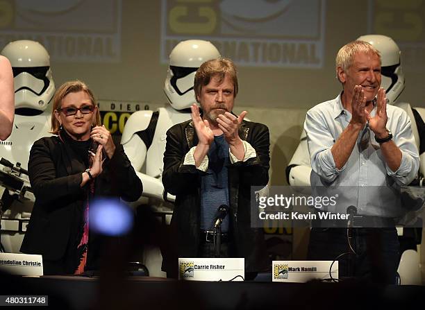 Actors Carrie Fisher, Mark Hamill and Harrison Ford applaud onstage at the Lucasfilm panel during Comic-Con International 2015 at the San Diego...