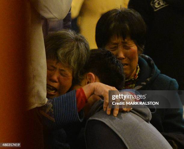 Grieving Chinese relatives of passengers on the missing Malaysia Airlines flight MH370 console each other after being told of their deaths at the...