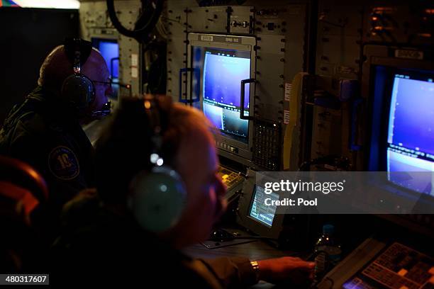 Crewmen on board an RAAF AP-3C Orion aircraft look at their radar screens during a search for missing Malaysia Airways Flight MH370 on March 24, 2014...