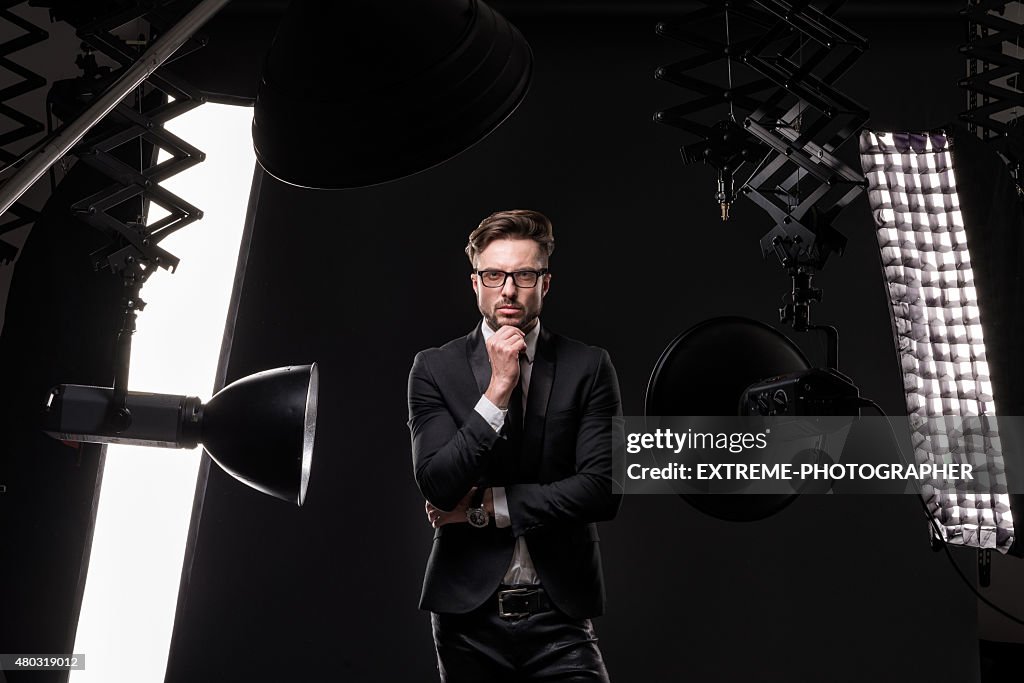 Giovane uomo alla moda in studio fotografico