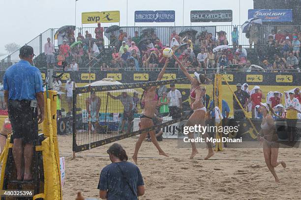 Jennifer Kessy and April Ross joust at the net while Kerri Walsh-Jennings looks on during a downpour at the AVP New Orleans Open at Laketown on May...