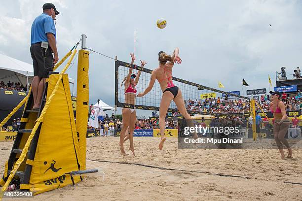 Emily Day jumps for a ball against April Ross as Jennifer Kessy looks on during the Women's Final at the AVP New Orleans Open at Laketown on May 24,...